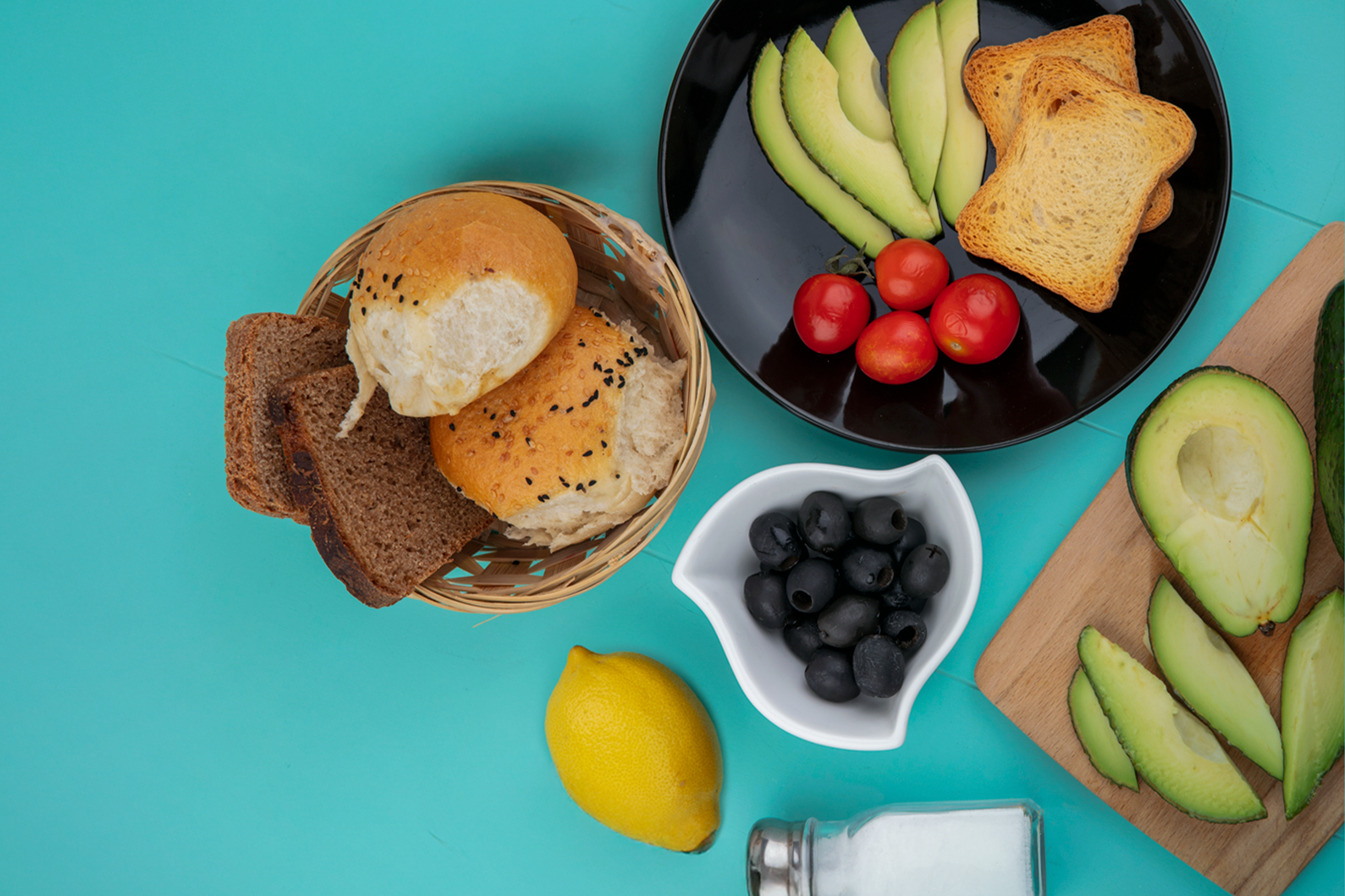 top-view-fresh-avocados-wood-kitchen-board-with-avocado-slices-tomatoes-black-plate-with-bucket-breads-blue-thymb